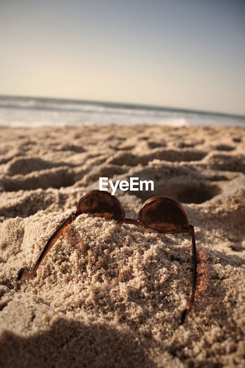 Close-up of water on sand at beach against to the horizon 