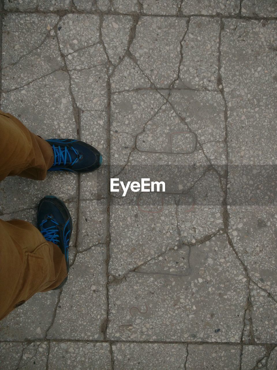 LOW SECTION OF MAN STANDING ON COBBLESTONE FOOTPATH