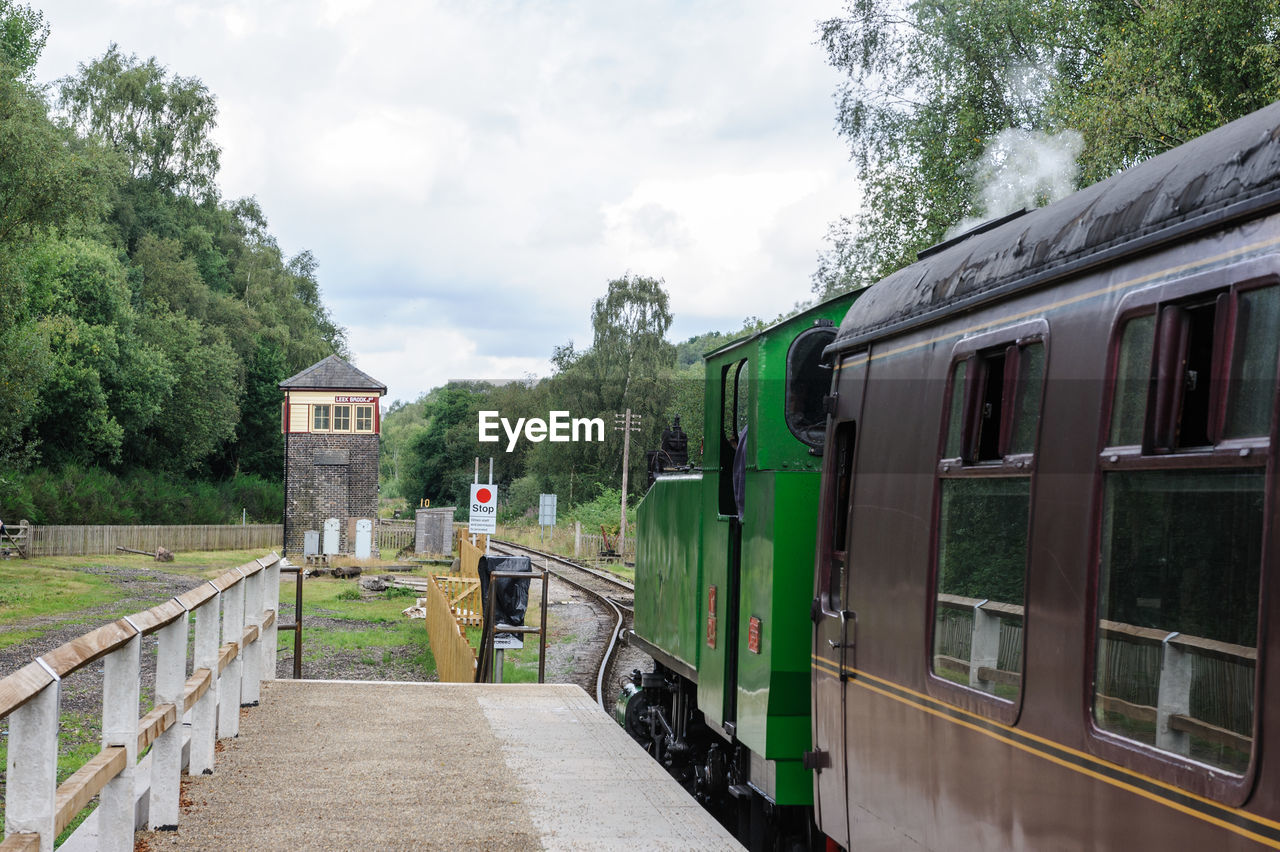 Trains moving at railroad station against sky