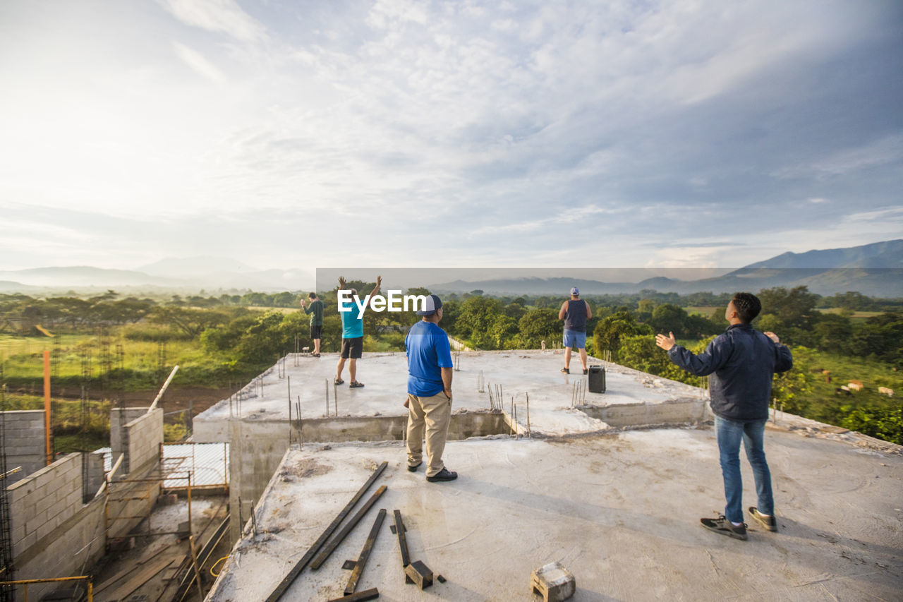 Group of men praising god from rooftop in the morning.