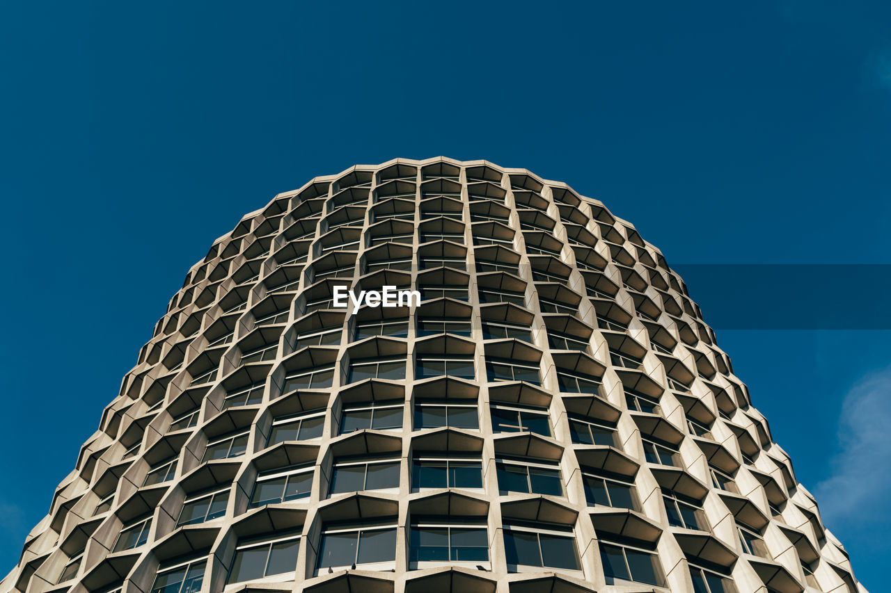 Low angle view of modern building against blue sky