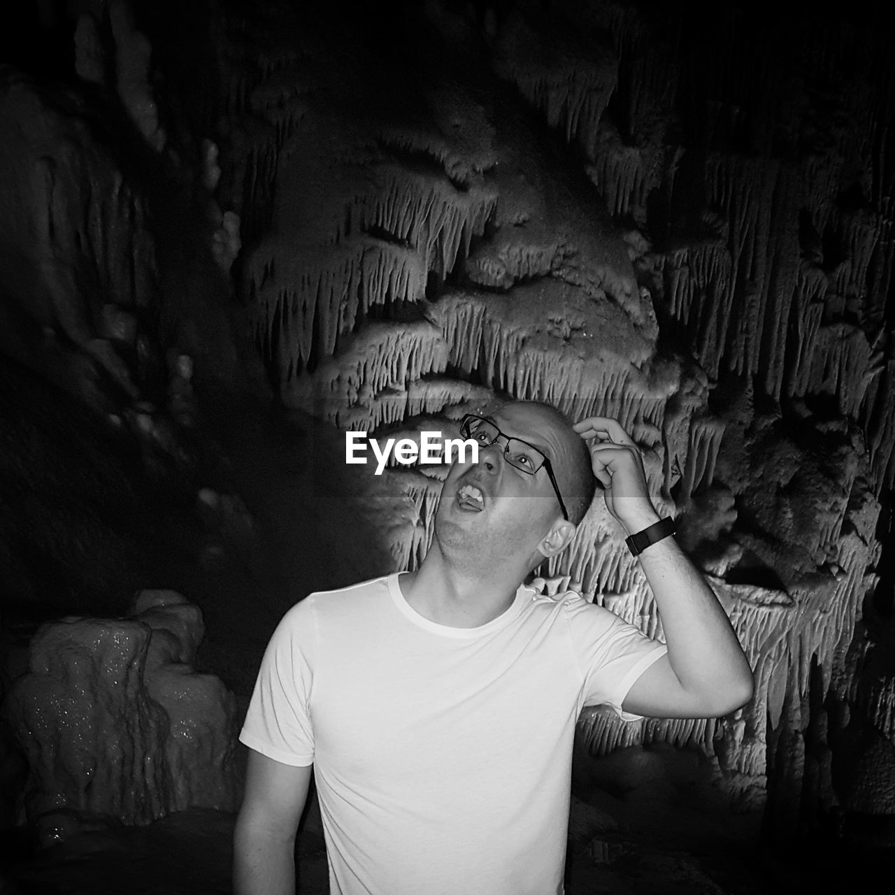 Confused man scratching head in cave