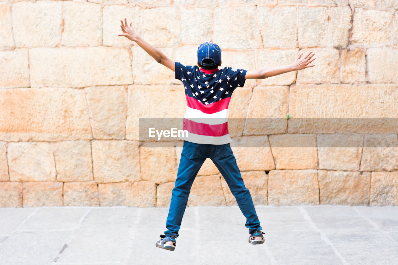 Boy jumping hands streched out