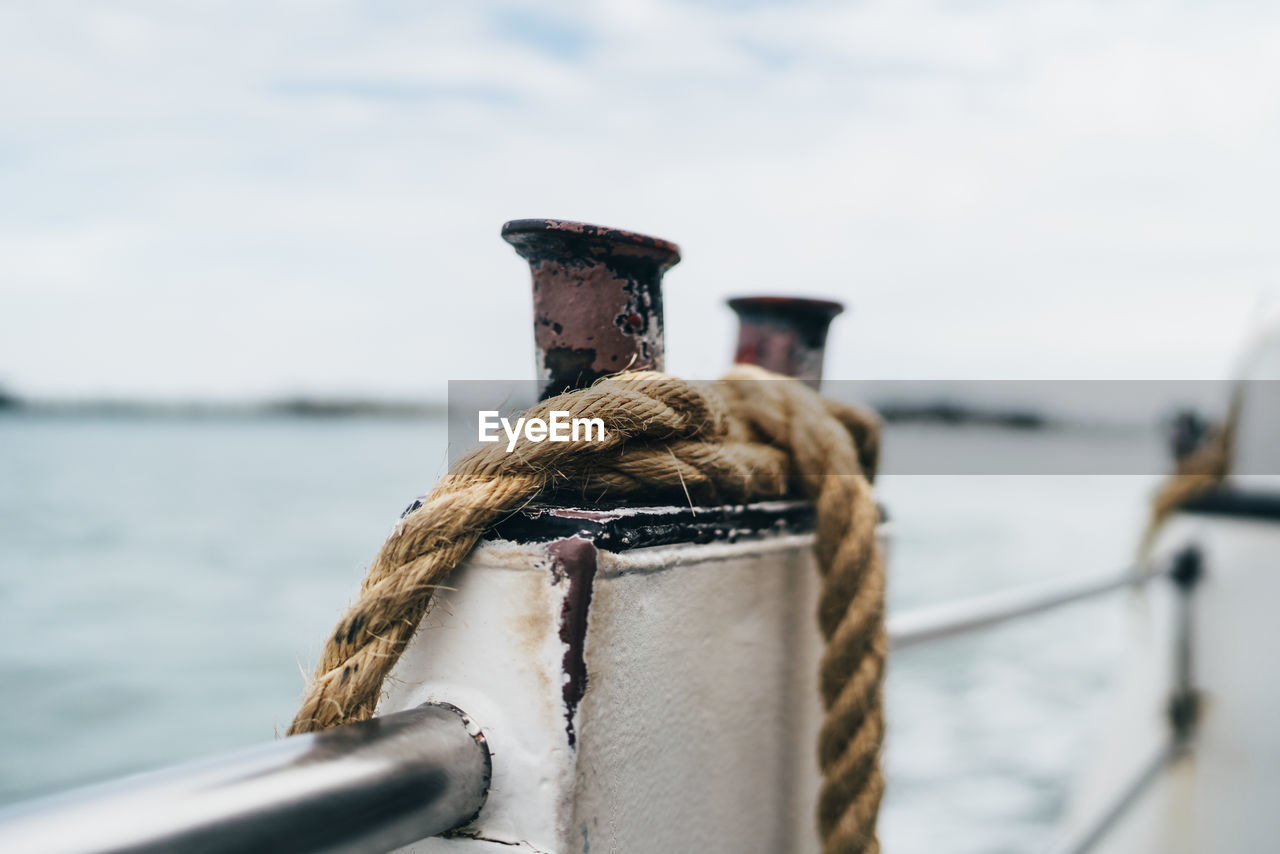 Close-up of rope tied to post of boat