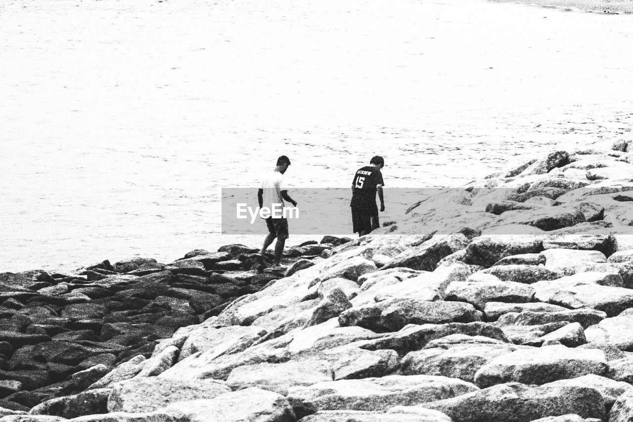 WOMAN STANDING ON ROCKS