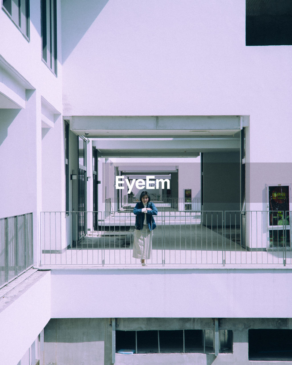 Woman standing in balcony of building