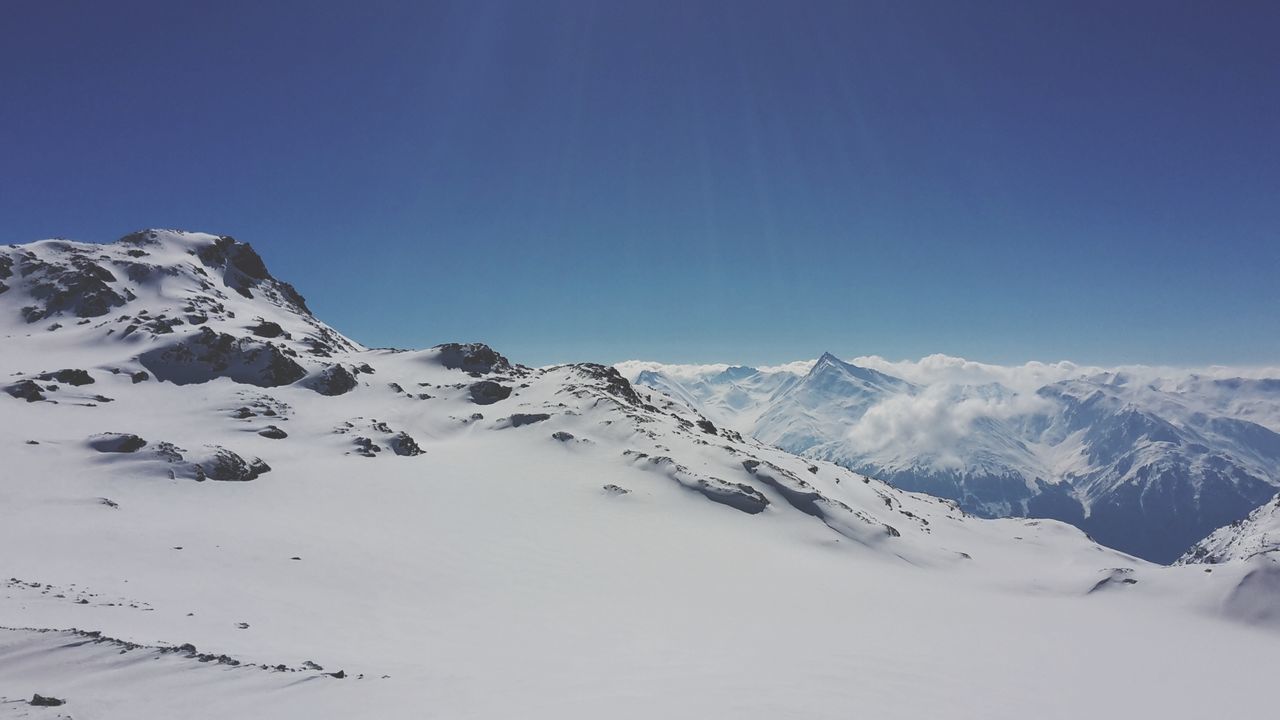 Scenic view of snowcapped mountains against clear blue sky