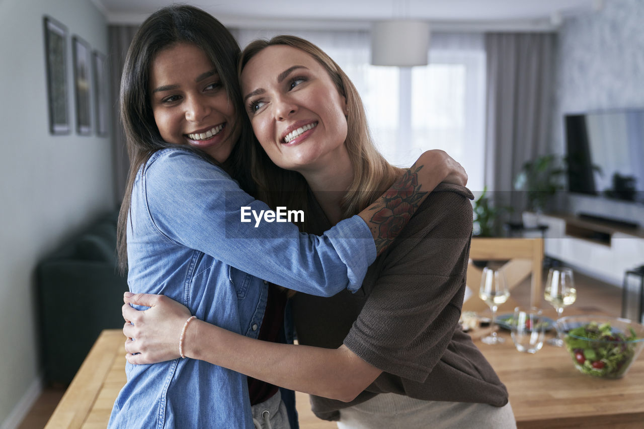 Female friends embracing at home