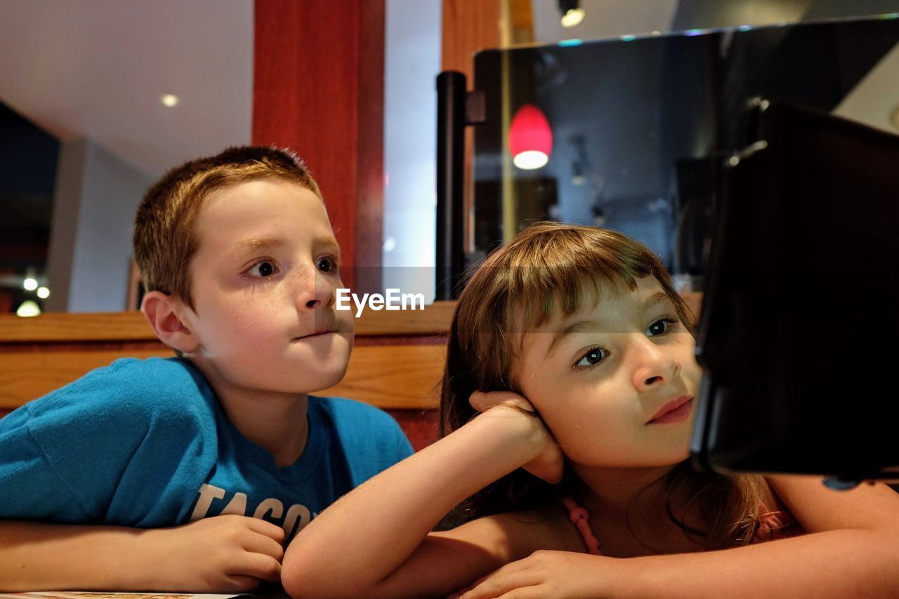 Close-up of siblings using digital tablet at table