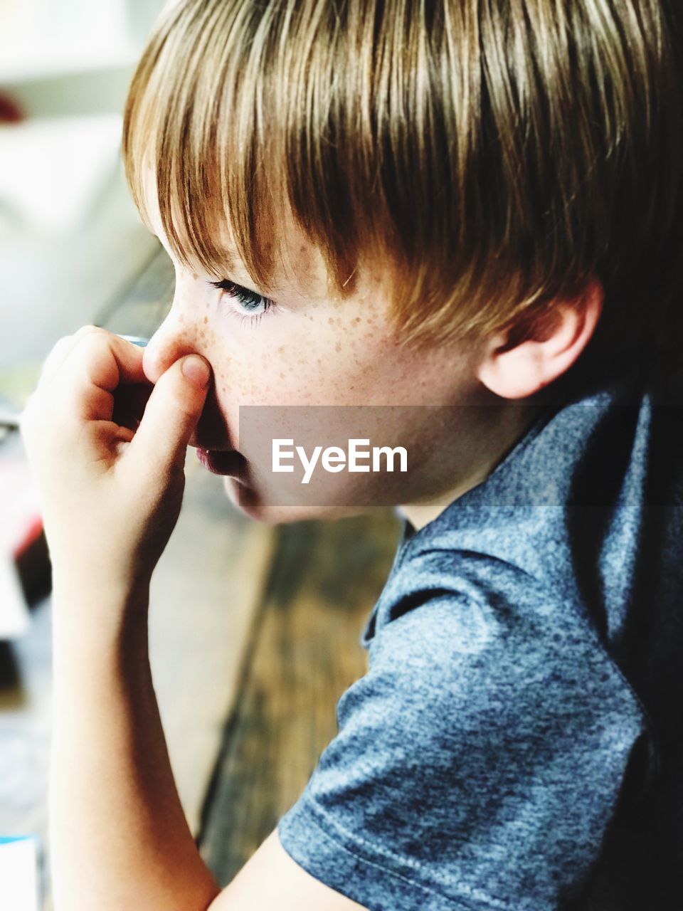 Close-up of boy holding nose