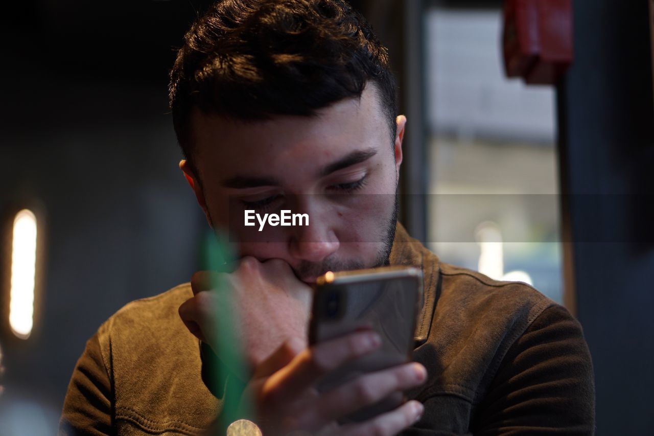 Young man using mobile phone at home