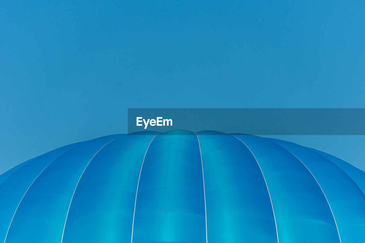 Low angle view of blue hot air balloon against blue sky