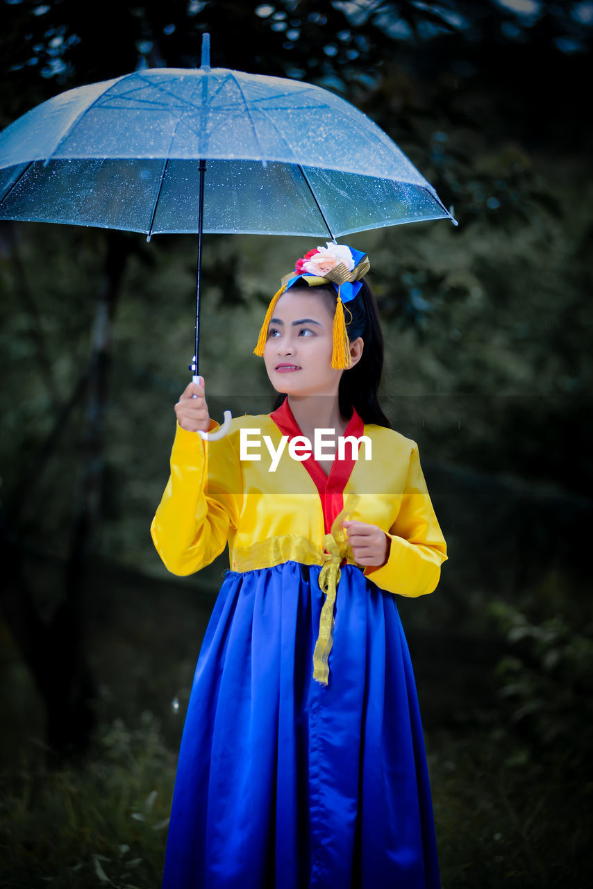 Portrait of young woman holding umbrella