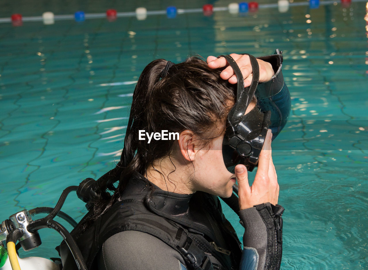 Young woman wearing scuba mask in swimming pool