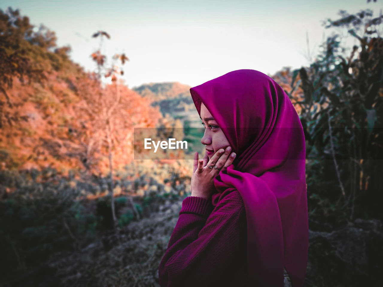 Side view of woman against trees