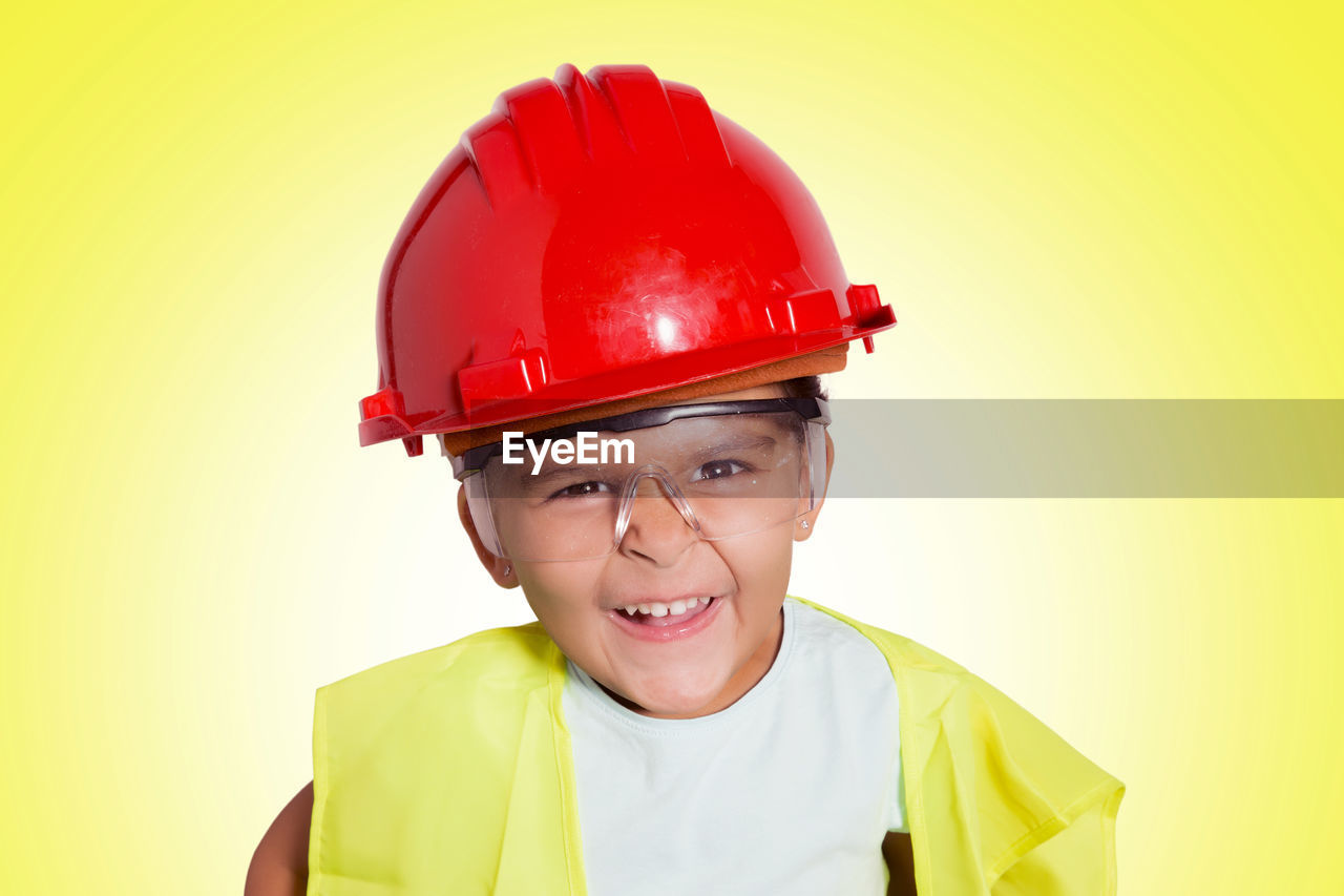 Portrait of boy wearing headwear against yellow background