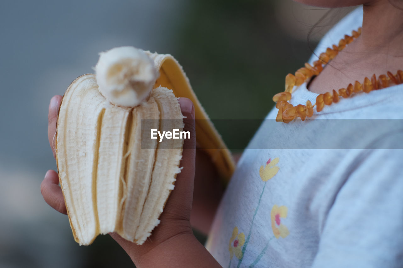 Close-up of child holding banana