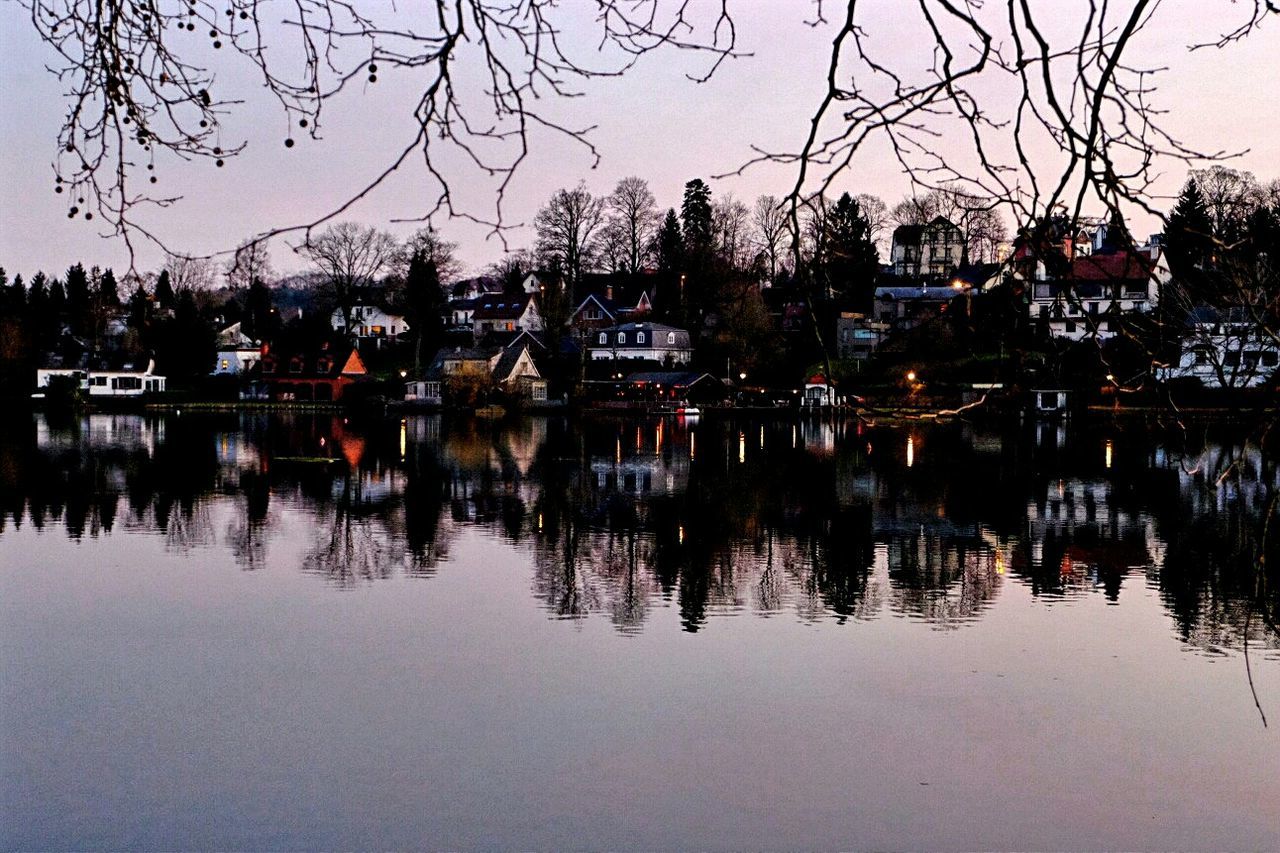 Houses by lake during dusk