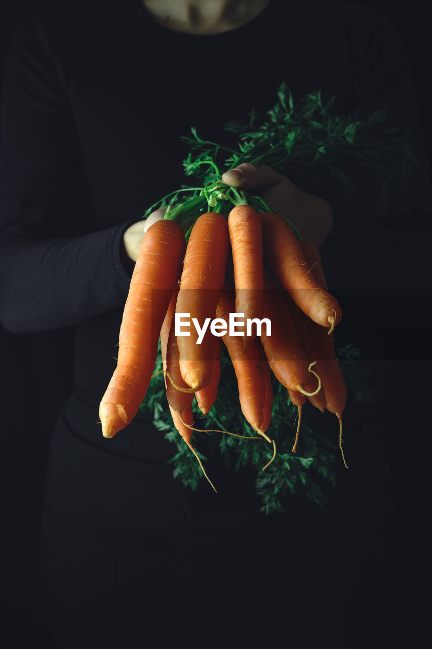 Man with fresh carrots. food background for recipes and books