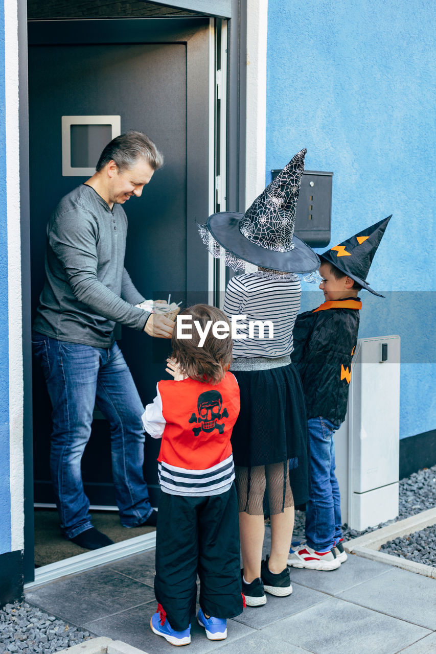 Halloween autumn holiday. a group of children in costumes go from door to door and collect sweets. 