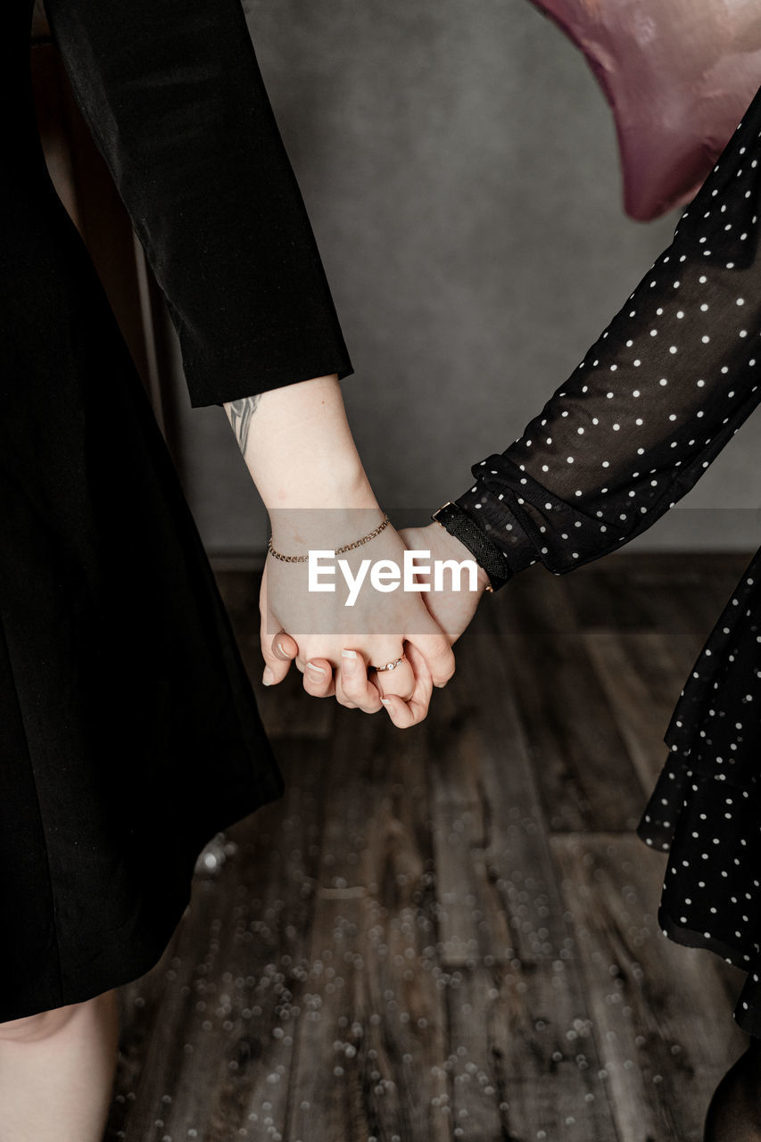 Cropped image of hands over wooden floor