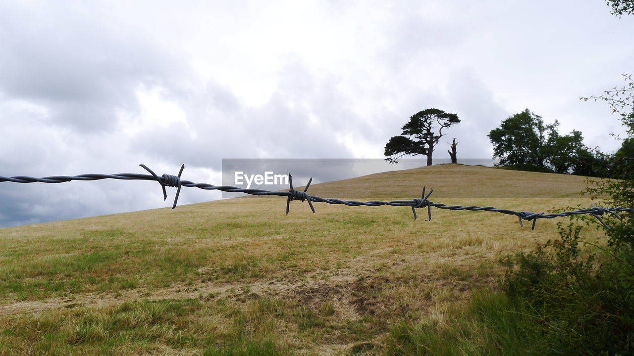 Fence on field against sky