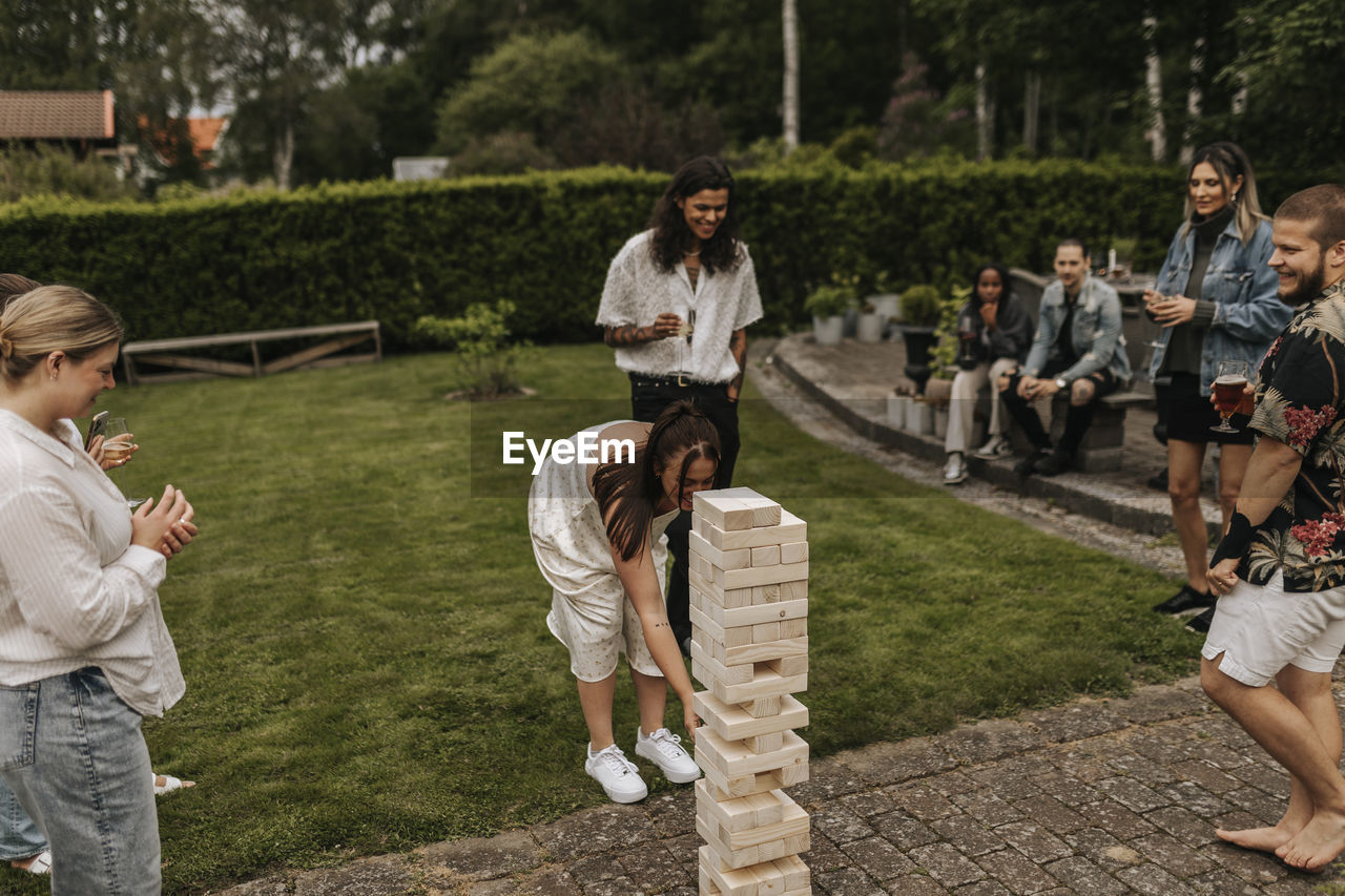 Friends playing jenga in garden