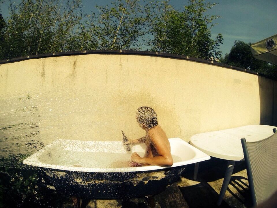 Man drinking beer in bathtub