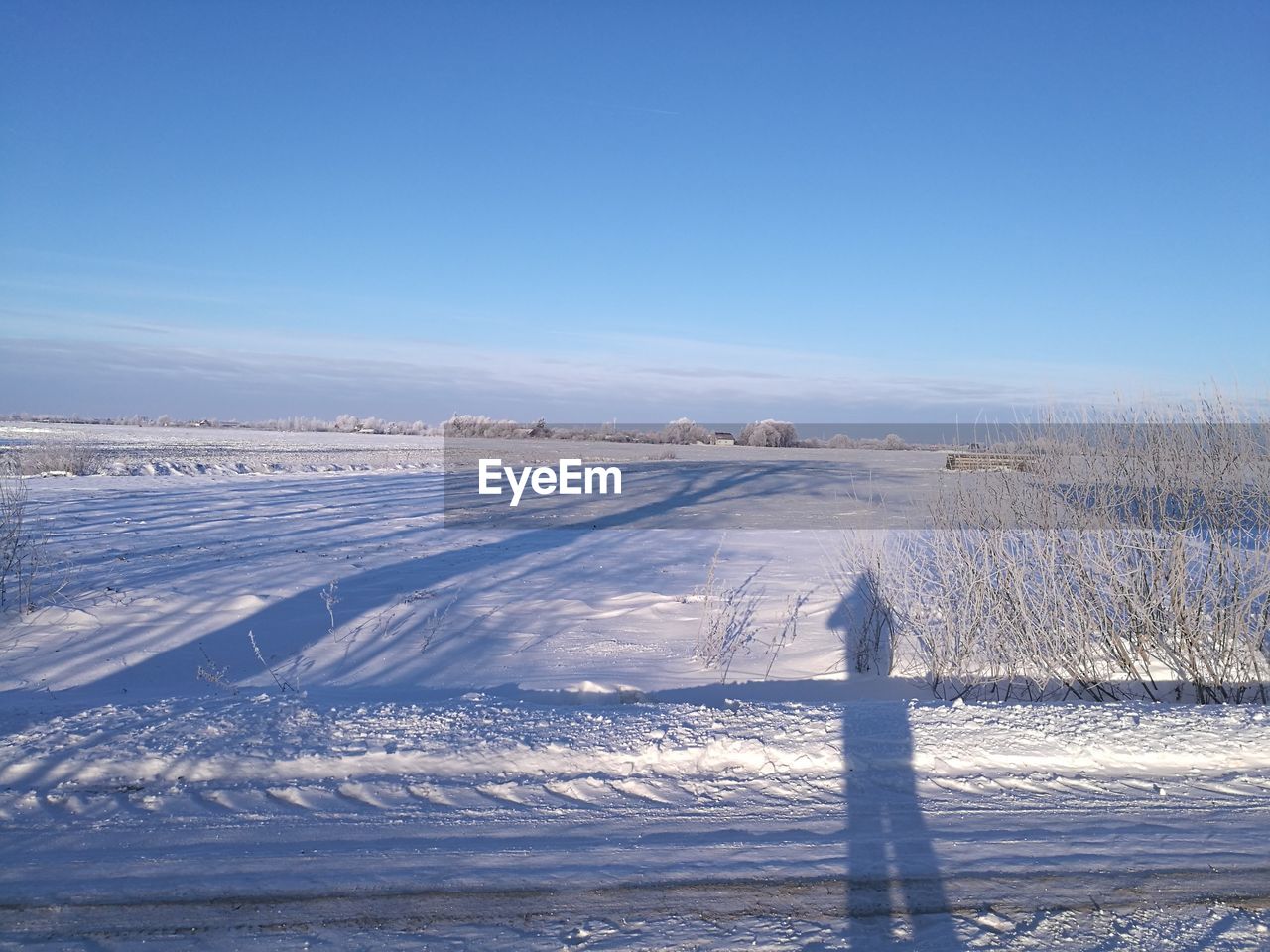 Scenic view of landscape against blue sky during winter