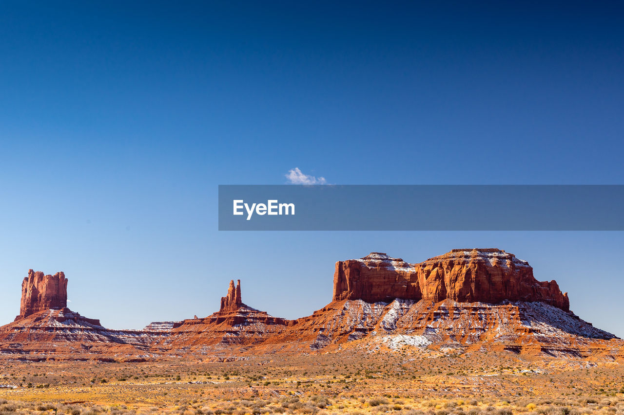 Rock formations in desert against blue sky