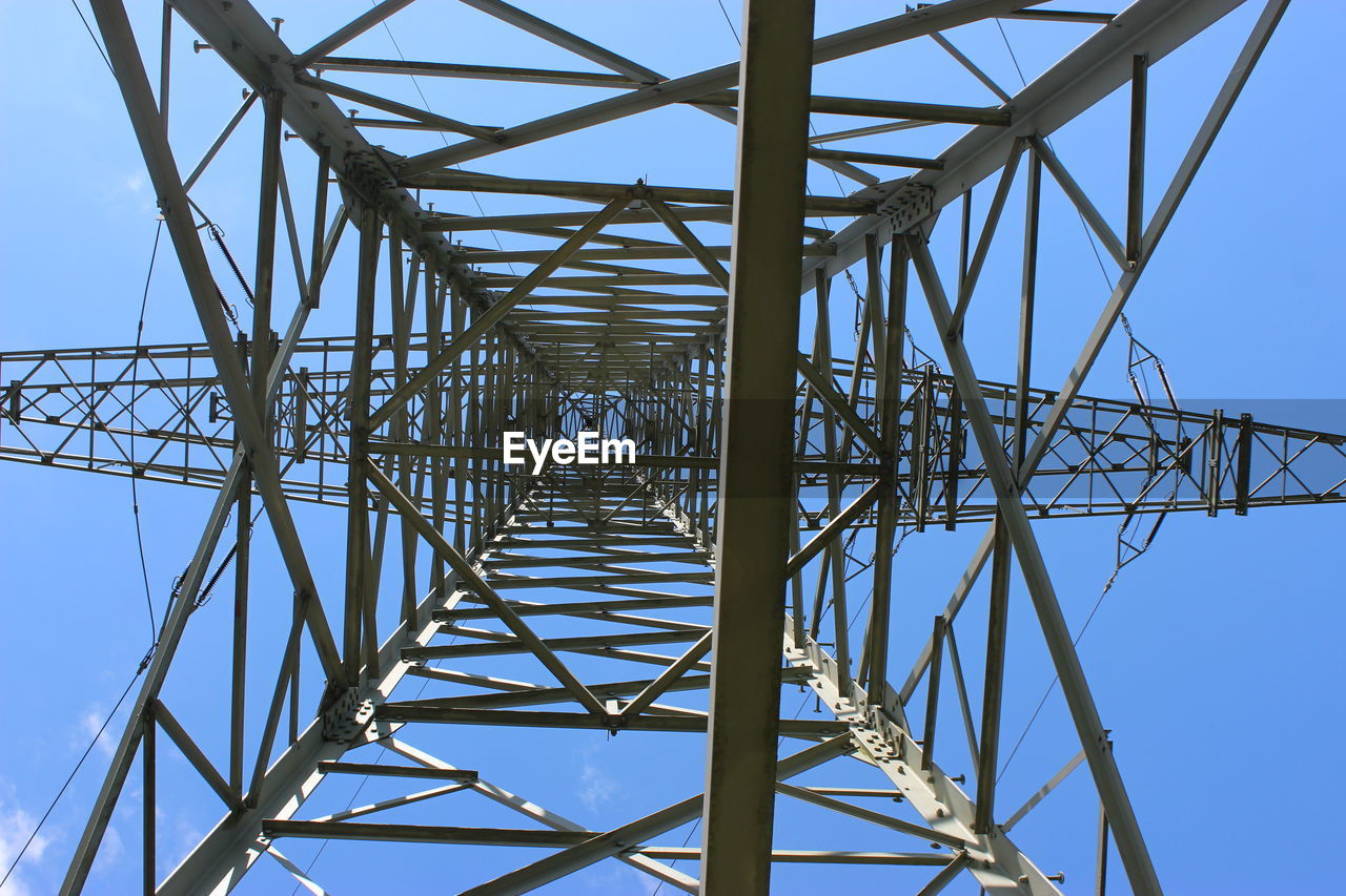 Directly below shot of electricity pylon against clear blue sky