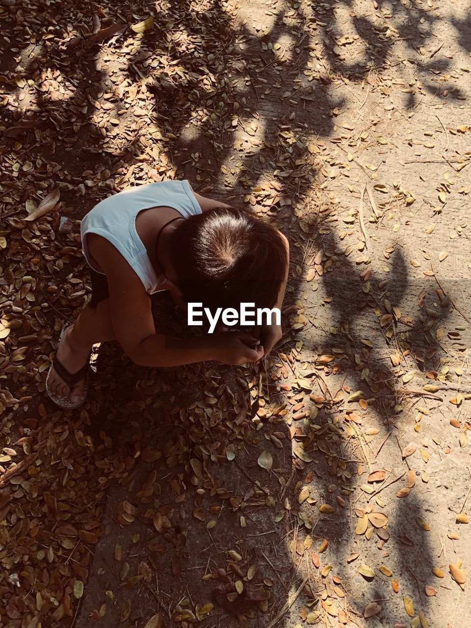 High angle view of boy crouching on field