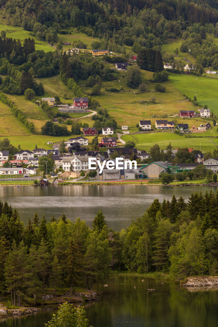 Houses by lake against sky