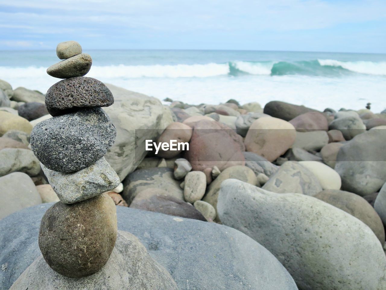 Close-up of pebbles on beach against sky