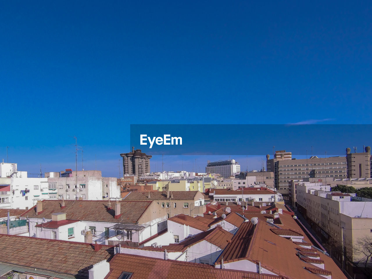 View of the city skyline from a rooftop in madrid, spain. it is a sunny day and the sky is blue