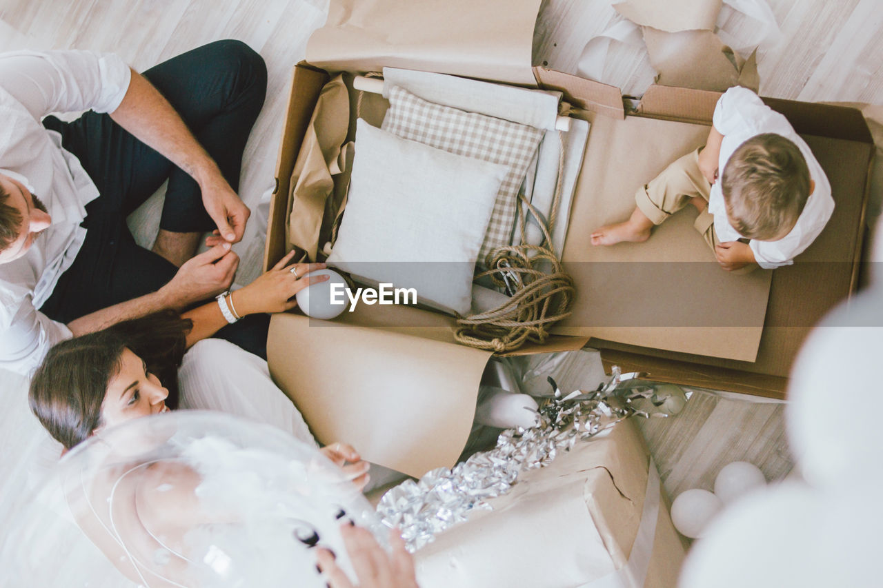 HIGH ANGLE VIEW OF PEOPLE RELAXING ON TABLE IN ROOM