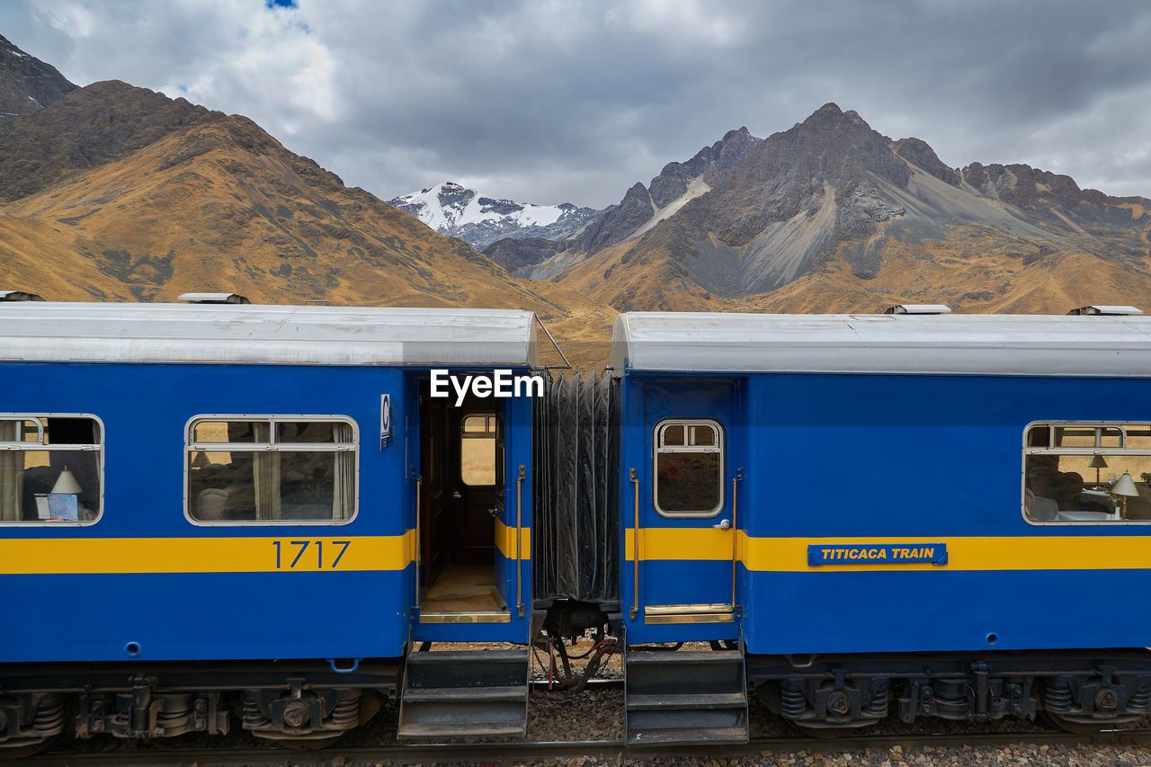 TRAIN AT RAILROAD STATION AGAINST SKY