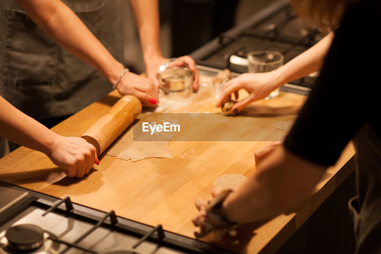 High angle view of people making cookies on kitchen counter