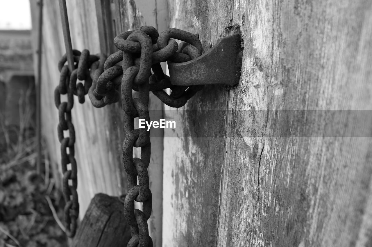 Close-up of door locked with metal chain