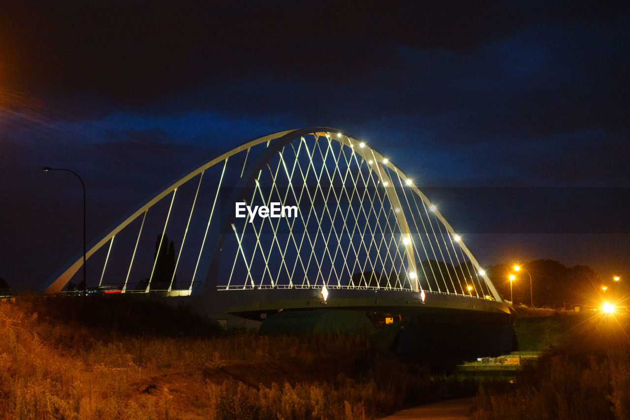 ILLUMINATED BRIDGE AGAINST SKY AT NIGHT