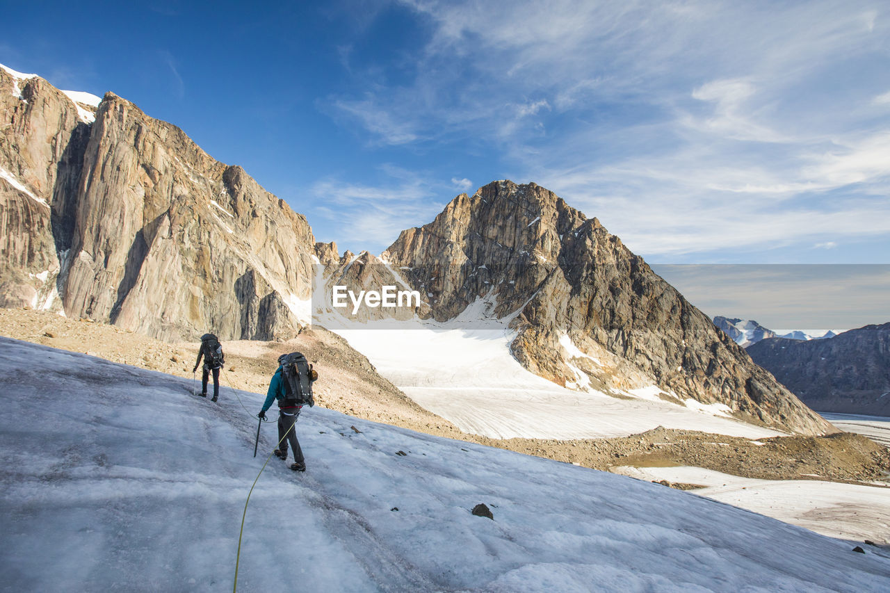 Climbers cross a glacier in akshayak pass, baffin island