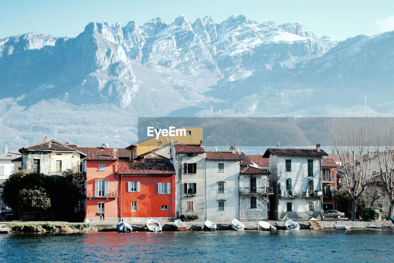 Houses at waterfront with mountain range in background