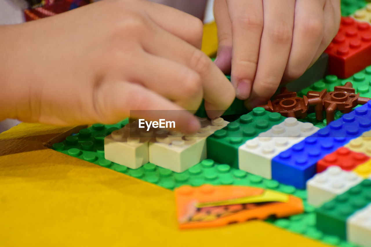 Cropped hands playing with colorful toy blocks