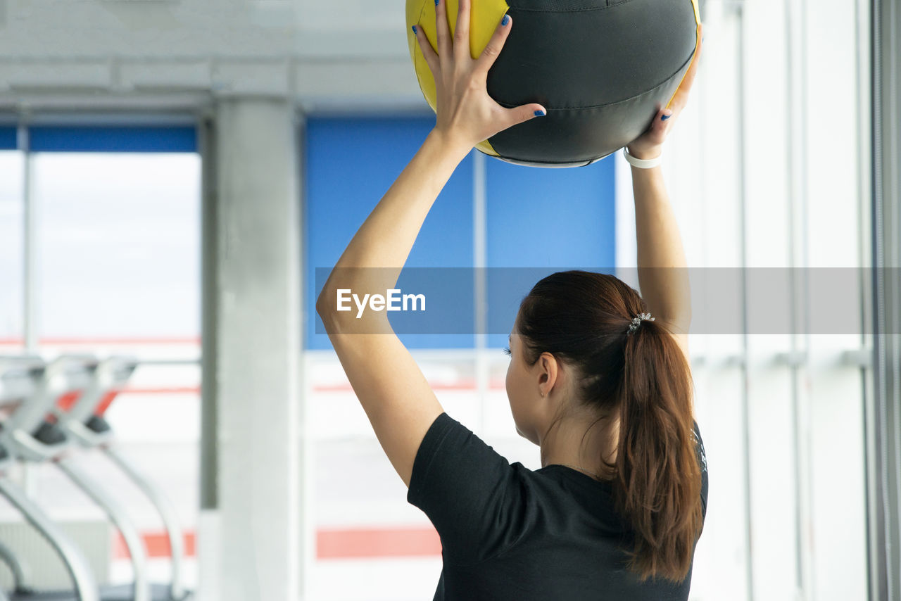 Rear view of woman exercising at gym