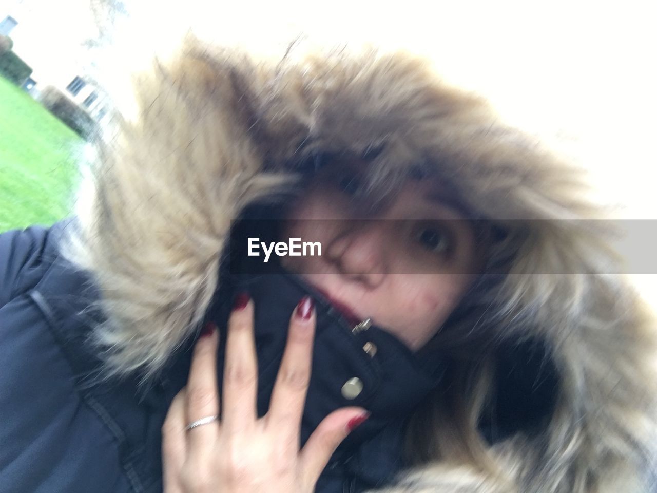 PORTRAIT OF YOUNG WOMAN WITH ICE CREAM ON SNOW