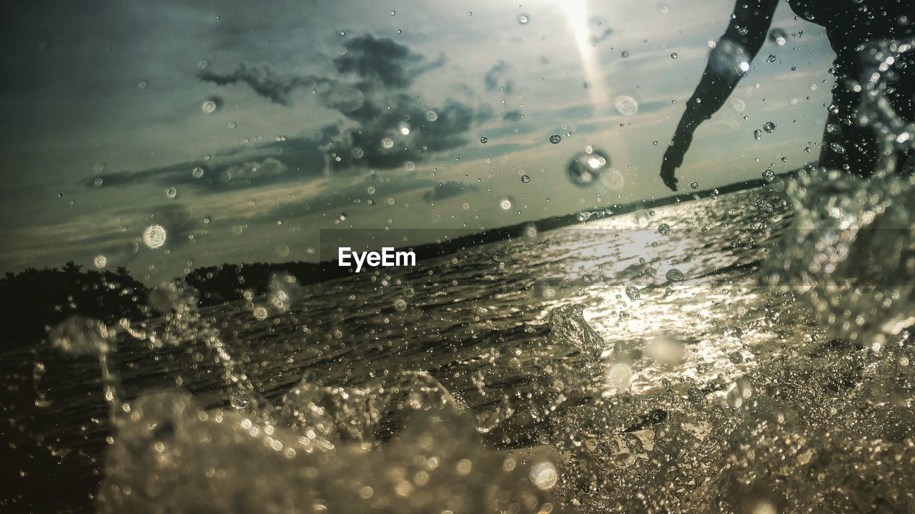 CLOSE-UP OF WATER SPLASHING ON GLASS WINDOW