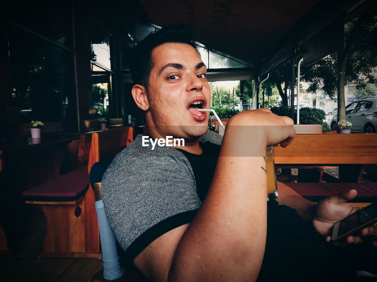 Portrait of man drinking while sitting in restaurant