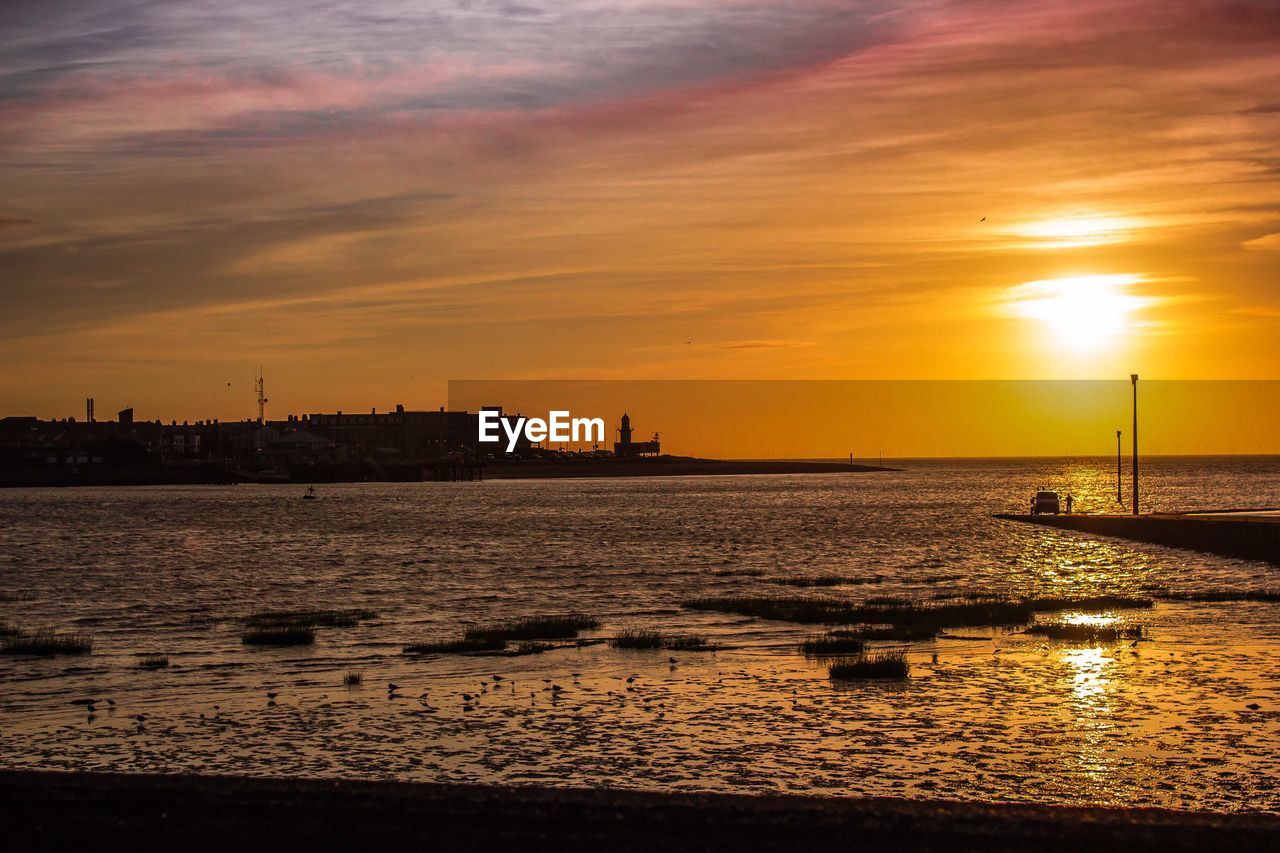 SCENIC VIEW OF SEA AGAINST ORANGE SKY DURING SUNSET