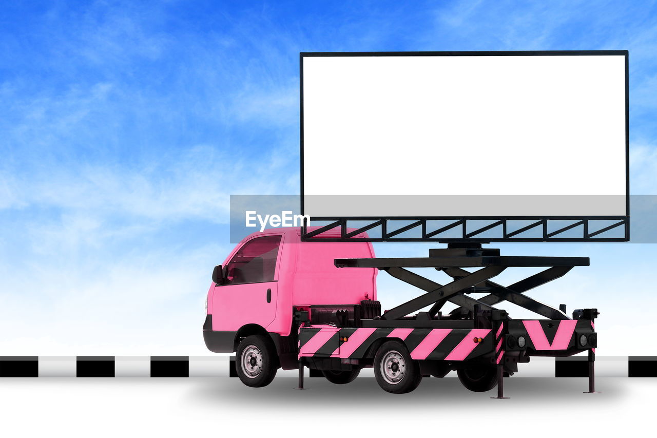 Digital composite image of truck with advertisement against blue sky