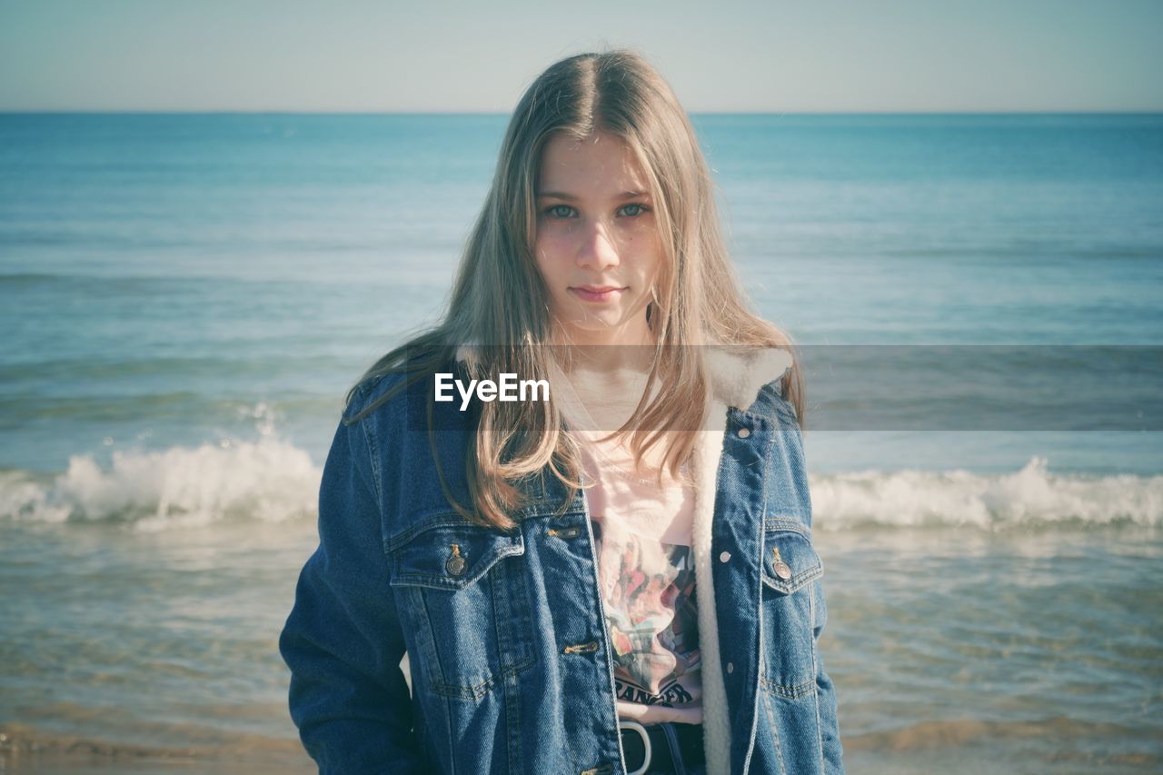 Portrait of girl standing on beach against sea